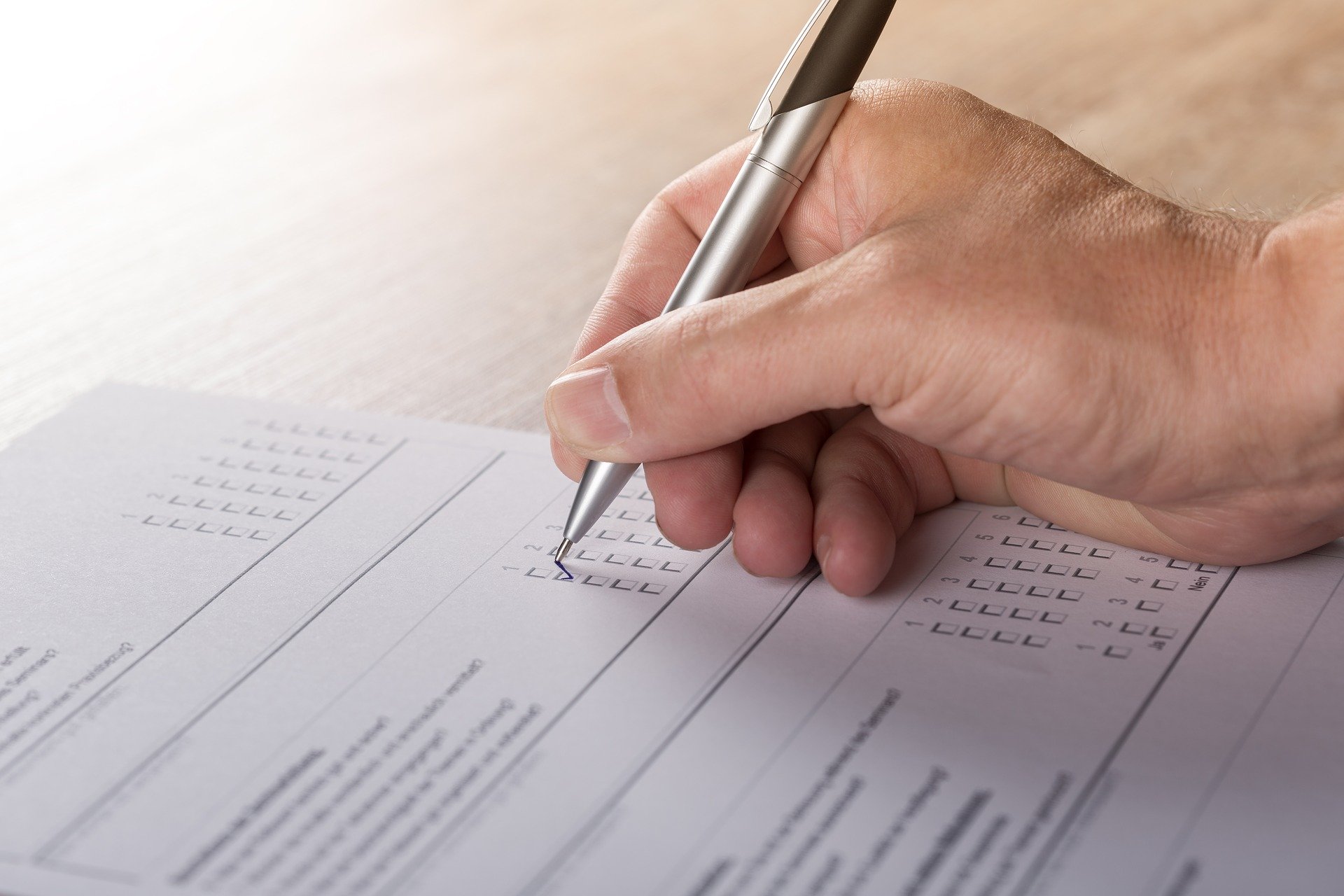 Hand mit Stift schreibt auf einem Blatt Papier