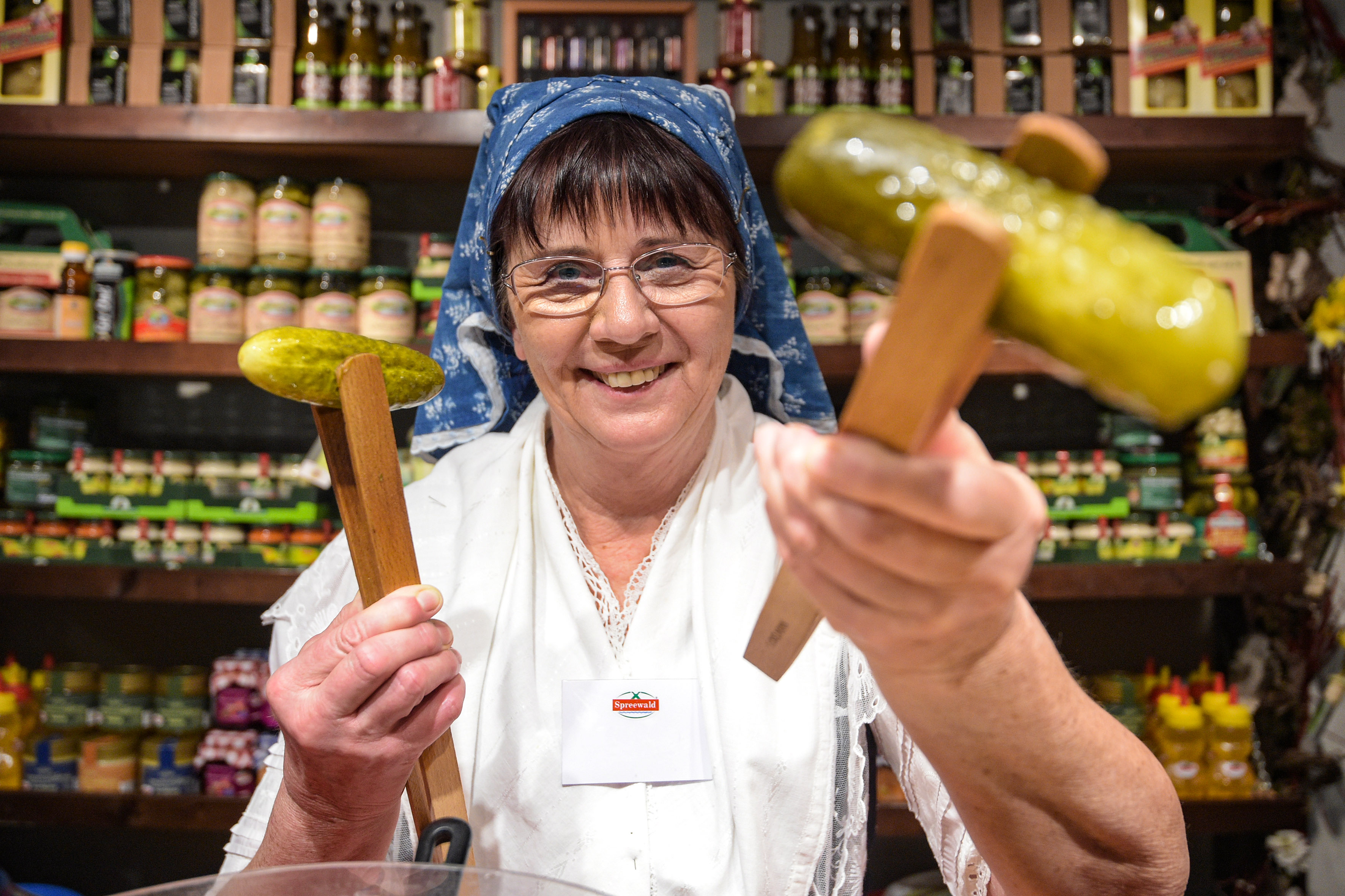 Verkäuferin in Spreewaldtracht mit Gurke