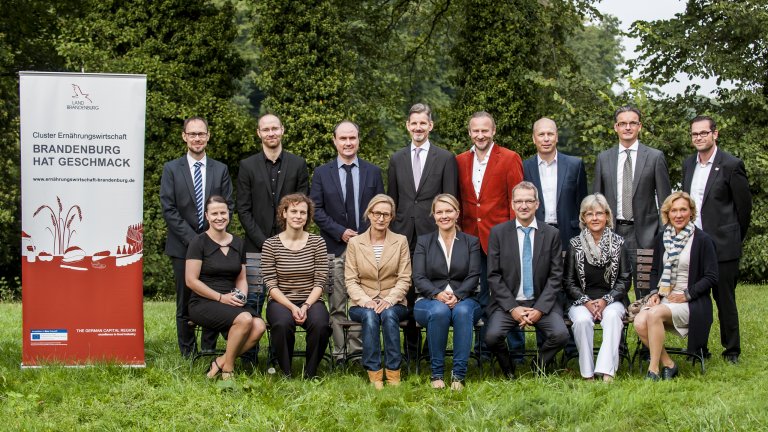 Ein Strategischer Beirat unterstützt die Arbeit im Cluster Portrait des Clusterbeirates auf einer Wiese vor Bäumen