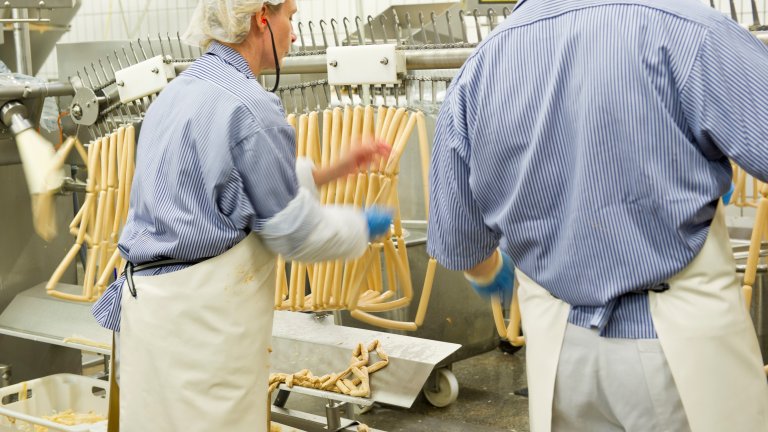 Mann und Frau verarbeiten Fleisch zu einer Wurst